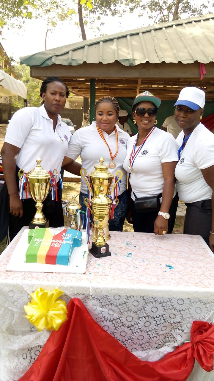 Baybos staff with trophies and cake on the first Sports and Fun Day