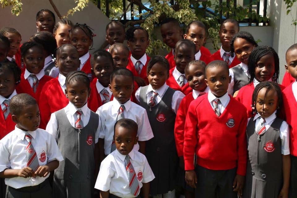 Baybos pupils in school uniform — red sweaters, striped ties, Baybos crest